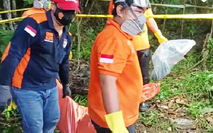 Anggota Kepolisian Polresta Samarinda mengevakuasi mayat Juwana dari lokasi penemuan. (foto : 1st)
