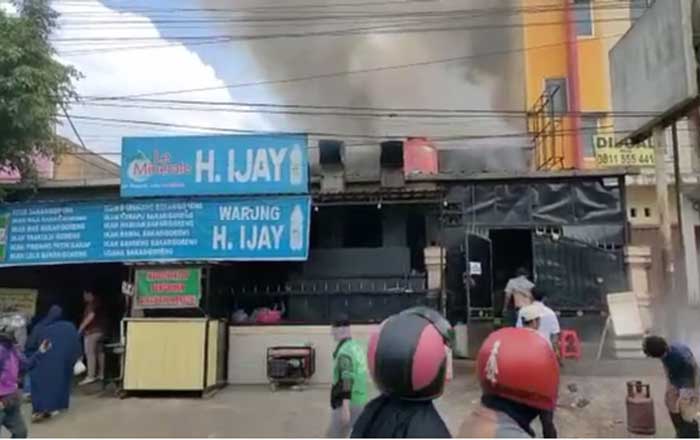 Kepulan asap terlihat keluar dari sela-sela atap Rumah Makan H.Ijay. (foto : 1st)