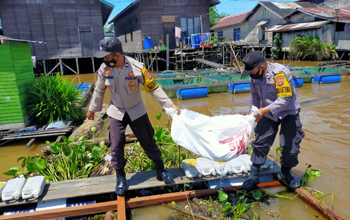 Anggota Polsek Tenggarong mengevakuasi mayat bayi perempuan dari lokasi penemuan. Kini pihak Kepolisian melakukan penyelidikan untuk mengungkap kasus yang membuat warga sekitar geger. (foto : 1st)