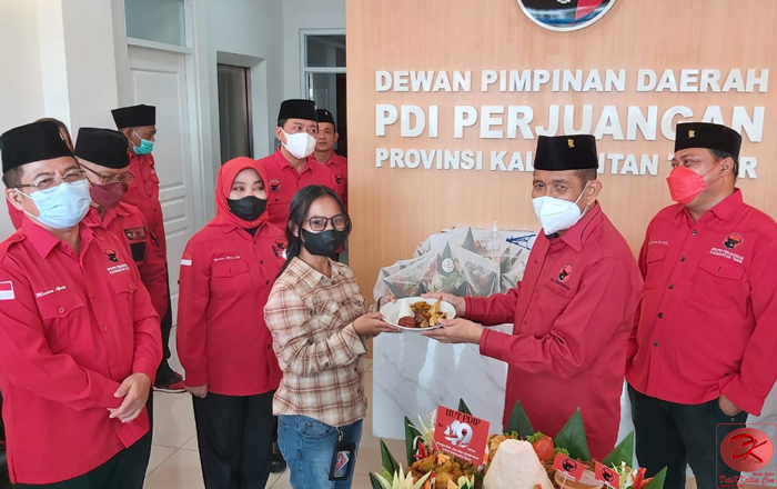 Ketua DPD PDI Perjuangan Kaltim Safaruddin menyerahkan potongan Tumpeng kepada salah seorang awak media yang hadir dalam HUT Ke-49 PDI Perjuangan. (foto : LVL)