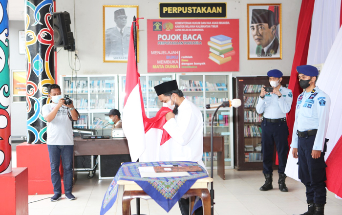 Narapidana teroris (Napiter) La Olani di Lapas Kelas IIA Samarinda berikrar setia kepada Negara NKRI seraya mencuim Bendera Merah Putih. (foto : Exclusive)