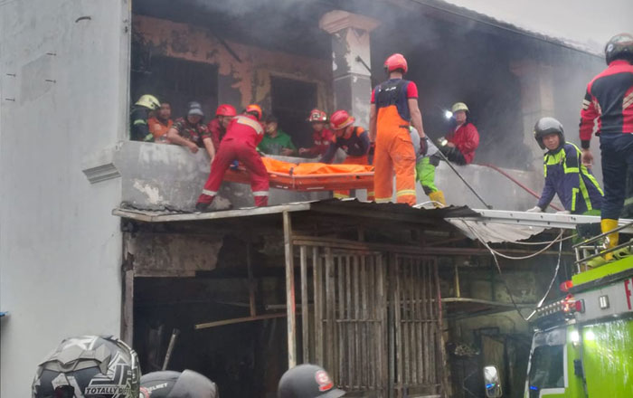 Petugas Dinas Pemadam Kebakaran dan Penyelamatan Kota Samarinda Bersama relawan dan masyarakat mengevakuasi korban dari dalam Ruko di lantai 2. (foto : Humas Polresta)