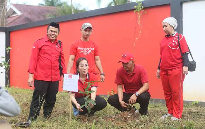Muhammad Samsun dan Ely Hartati Rasyid menanam pohon buah di sekitar Sekretaria DPC PDIP Kutai Kartanegara. (foto : Exclusive)