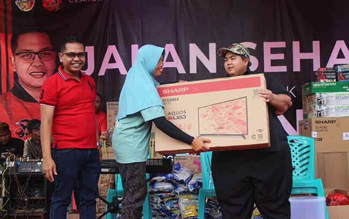 Anggota DPRD Kaltim Ananda Emira Moeis serahkan hadiah kepada seorang peserta Jalan Sehat yang beruntung mendapatkah doorprize berupa TV. (foto: Exclusive)