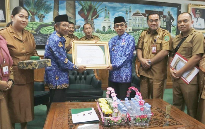 Kepala Dinas Tenaga Kerja dan Transmigrasi Sudirman Latif Kutim serahkan Penghargaan Mendes PDTT RI kepada Ardiansyah Sulaiman. (foto: Exclusive)