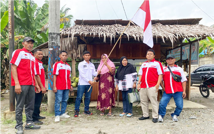 Ketua SMSI Binjai-Langkat Siswanto Ihsan,SE serahkan Bendera Merah Putih kepada warga. (foto: Exclusive)
